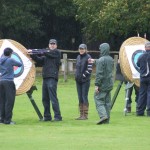 Archers pulling out arrows from targets.