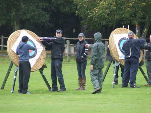 Archers pulling out arrows from targets.